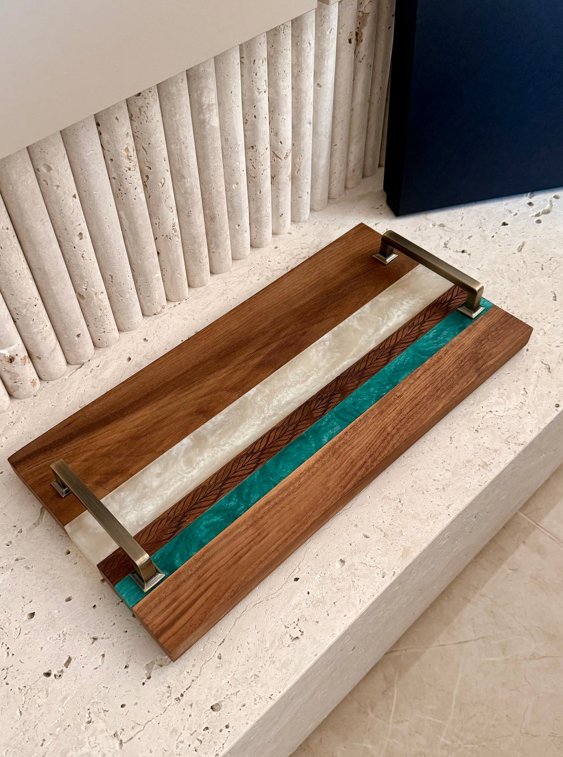 Wooden tray with a teal resin inlay on a textured surface